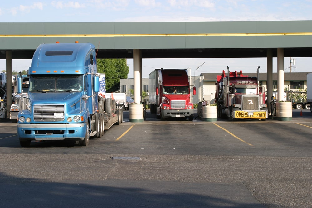 Semi trucks fueling at a truck stop.
