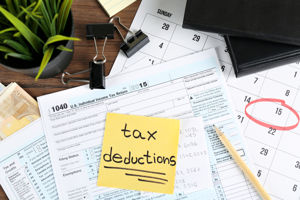 tax documents with a sticky note on it reading "tax deductions"