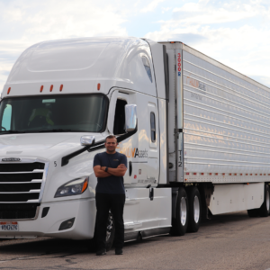 Man Standing next to haulin assets semi truck